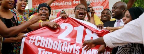 Members of the #BringBackOurGirls (#BBOG) campaign react on the presentation of a banner which shows "218", instead of the previous "219", referring to kidnapped Chibok school girls, during a sit-out in Abuja