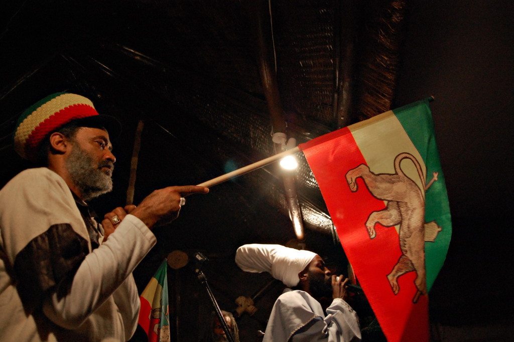A Rasta man holds the former Ethiopian flag with the golden crowned lion, a version used during the reign Ethiopia's last emperor Haile Selassie, at a local restaurant in Addis Ababa on November 1, 2009. The magnificent coronation ceremony for Ethiopia's last emperor Haile Selassie had a global impact, but 80 years on fewer than 100 people gathered to mark its anniversary. No official celebrations have been organised in Ethiopia -- just a few dozen Rastafarians and some of Selassie's former aides and officers met in a cultural centre in Addis Ababa.The participants gave their memories of Selassie to a background of reggae music, while outside some children watched the ceremony with curiosity. AFP PHOTO/Aaron MAASHO (Photo credit should read AARON MAASHO/AFP/Getty Images)